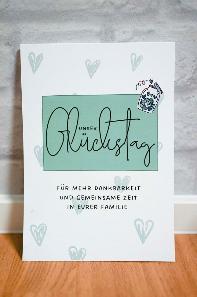 Liebevoll gestalteter Abreißblock Unser Glückstag für Familien auf einem Holztisch